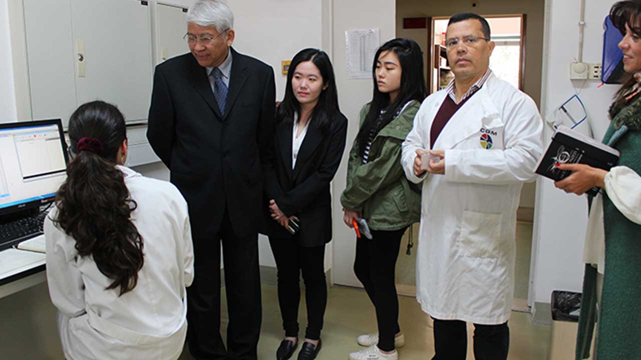 Rector of the City University of Macau talking with junior CQM researcher Fátima Mendes.